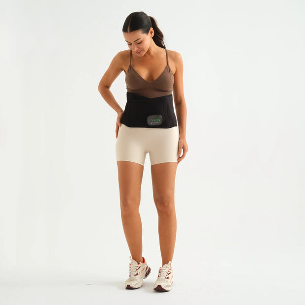 Woman wearing a WAGNUM ThermaRelief PRO Waist, showcasing its sleek design and digital display, ideal for pain relief and improved circulation with heat and vibration features.